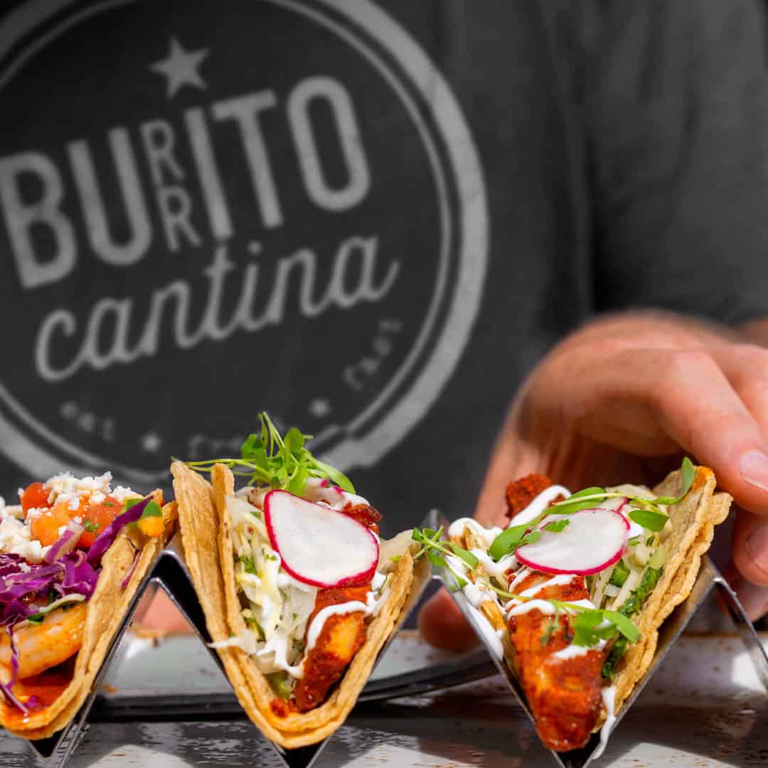 Close up of branded aprons created by Swan creative and Buritto Cantina tacos served by Tugo food solutions in square format
