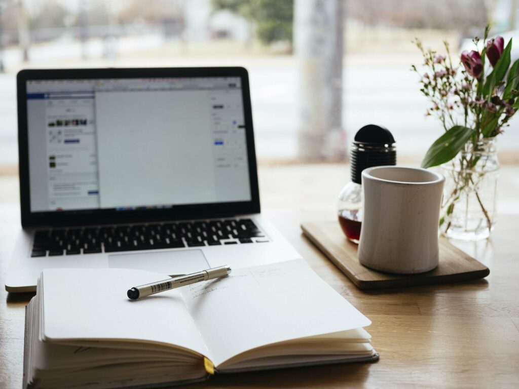 Open book and laptop on a desk